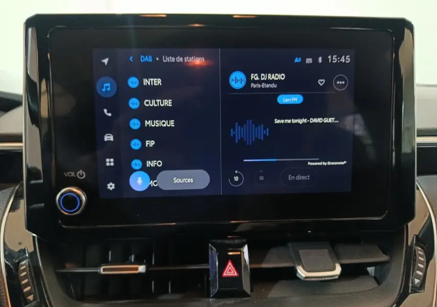 Écran tactile central de la Toyota Corolla hybride 2022 affichant une interface radio numérique en intérieur.