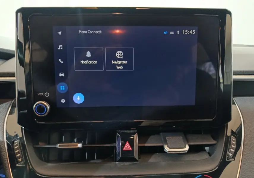 Écran tactile central noir affichant le menu connecté dans l'habitacle de la Toyota Corolla hybride 2022.