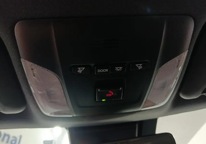 Vue en gros plan du plafonnier intérieur noir de la Toyota Corolla hybride 2022 avec boutons d'éclairage et alerte SOS.