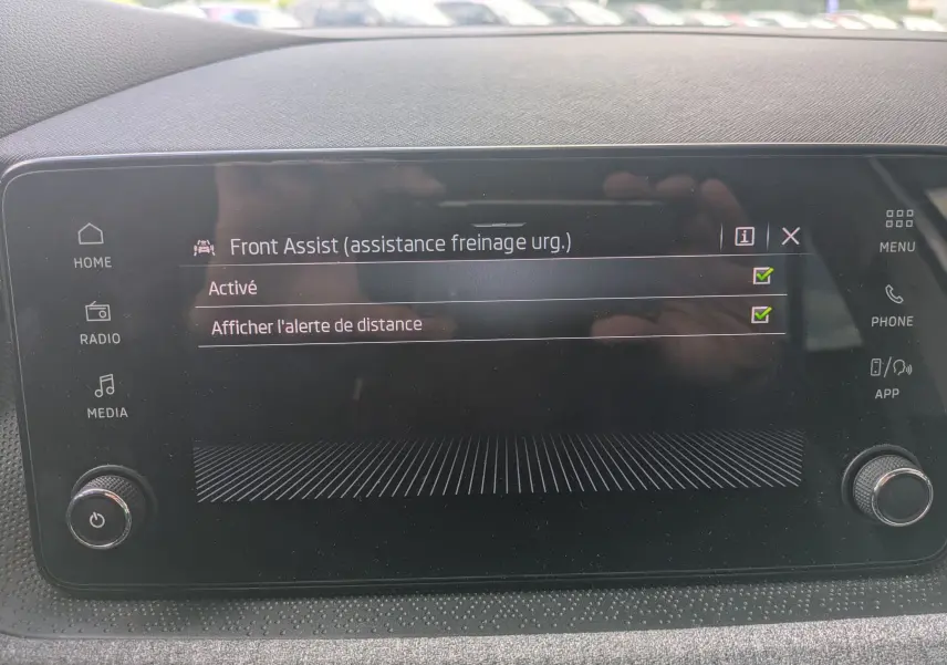 Écran tactile intérieur de la Skoda Scala gris reflex montrant l'activation de l'assistance freinage d'urgence Front Assist.