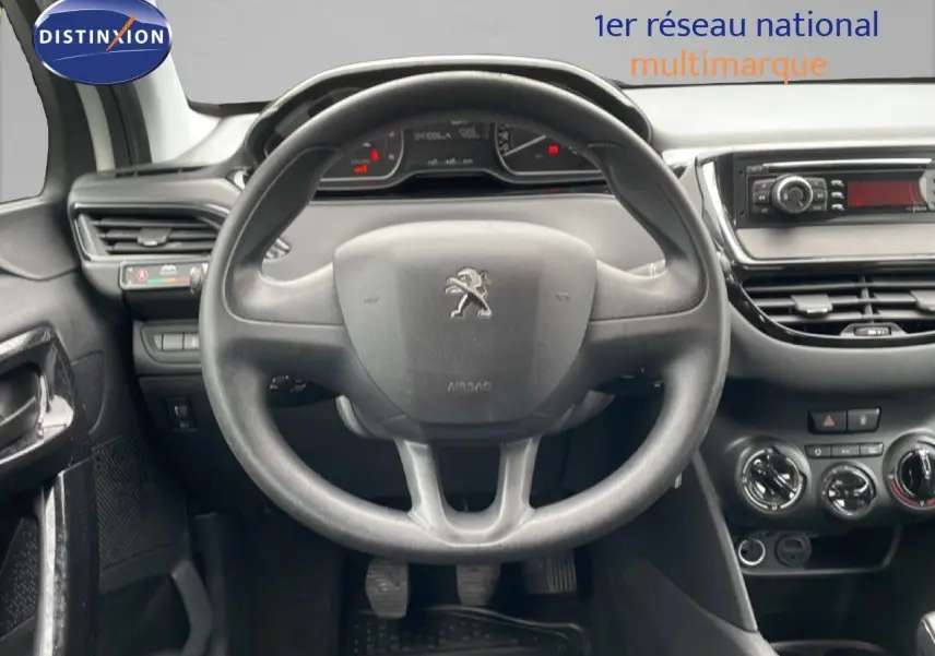 Vue intérieure centrée sur le volant noir de la Peugeot 208 Société 2018, avec tableau de bord et commandes visibles.