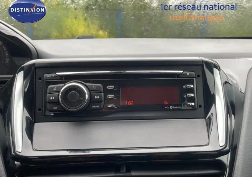 Vue rapprochée du tableau de bord de la Peugeot 208 Société 1.6 HDI 75ch Premium, avec système audio intégré.