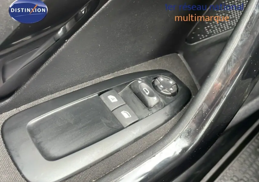 Gros plan sur les commandes de lève-vitres et réglage des rétroviseurs côté conducteur d'une Peugeot 208 Société blanche.