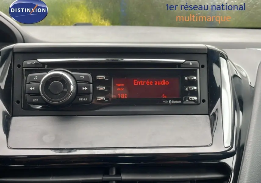 Vue rapprochée de la console centrale noire du Peugeot 208 Société 2018 avec écran audio affichant "Entrée audio".