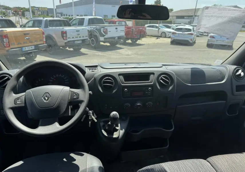 Vue intérieure du poste de conduite du Renault Master blanc 2019, avec volant, tableau de bord et levier de vitesses manuel visibles.