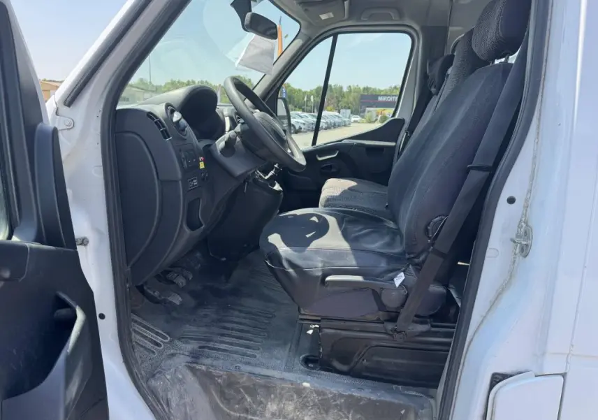 Vue intérieure côté conducteur du Renault Master blanc 2019, montrant les sièges avant et le tableau de bord simple.