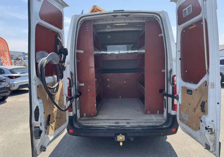 Vue arrière ouverte du Renault Master blanc 2019 avec aménagements en bois et étagères dans la zone de chargement.