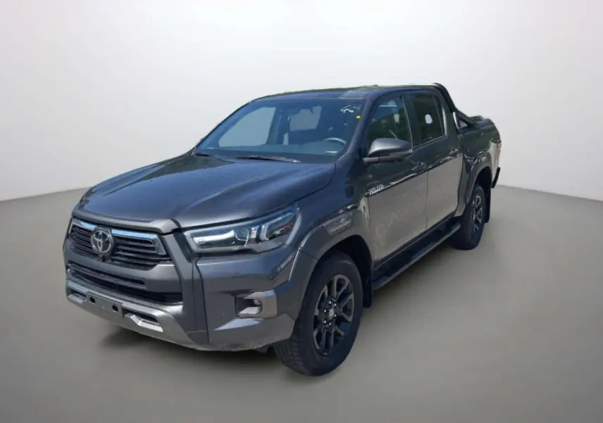 Toyota Hilux 4x4 gris atlas en 3/4 avant droit avec arceaux et rideau coulissant manuel sur la benne.
