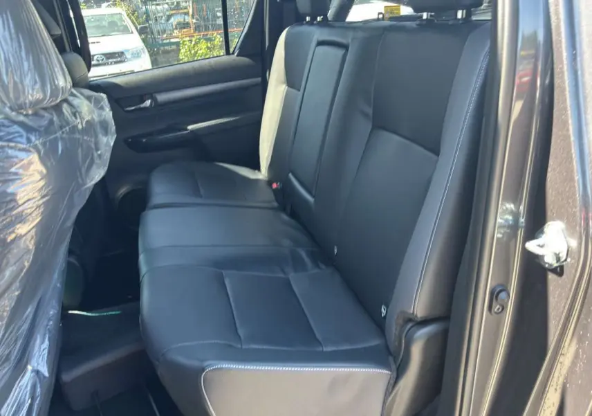 Vue intérieure côté droit montrant la banquette arrière en cuir noir du Toyota Hilux 4x4 gris atlas 2026.