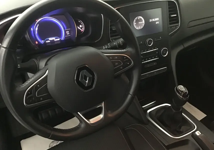 Vue intérieure côté conducteur de la Renault Mégane IV Business 2019, volant cuir noir et levier de vitesse manuel visibles.