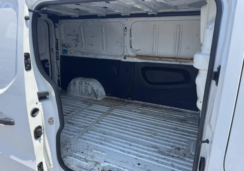 Vue intérieure arrière du Renault Trafic Fourgon blanc 2019, montrant l'espace de chargement vide et usé.