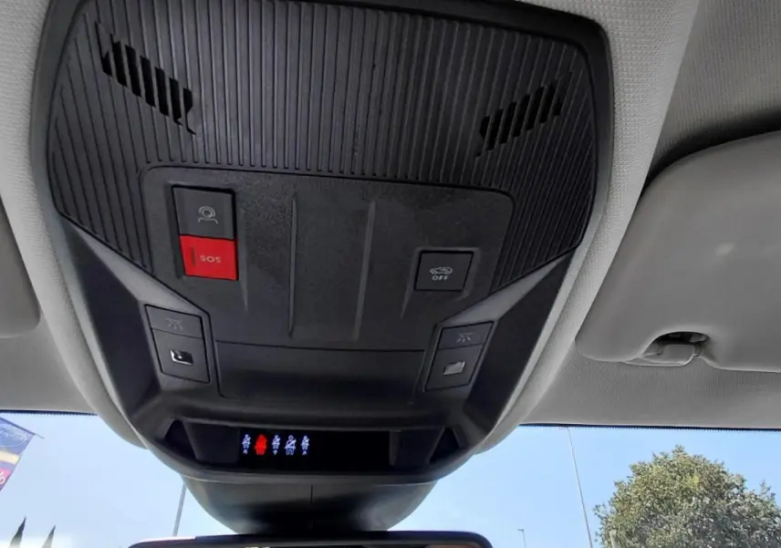 Vue intérieure en contre-plongée du plafonnier avec boutons SOS et commandes d’éclairage du Peugeot 308 SW gris.