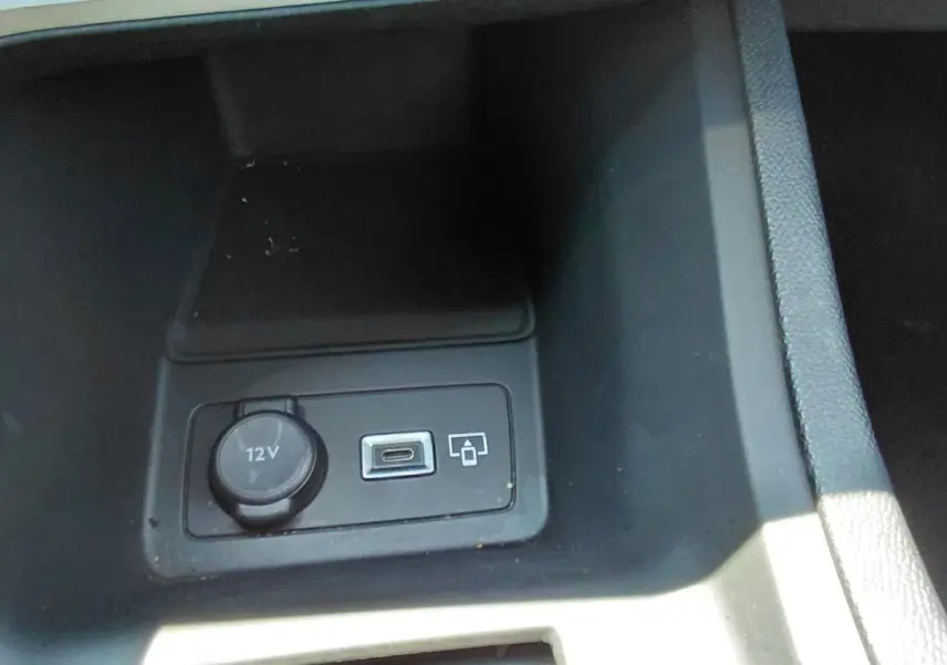 Prise 12V et port USB dans le compartiment central avant d’une Peugeot 308 SW gris, version Hybrid 145 e-DCS6 Allure.