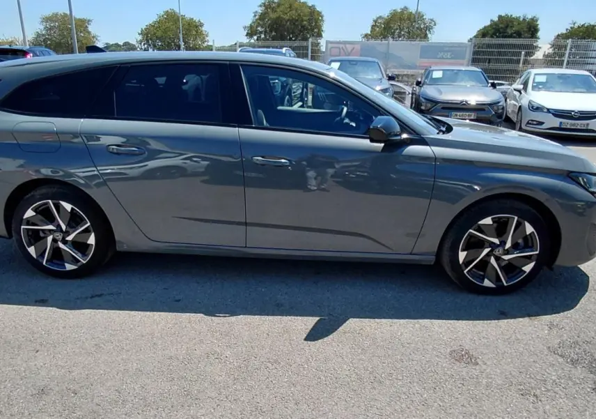 Peugeot 308 SW Hybrid gris vue de profil côté gauche, avec jantes alliage 17 pouces et vitres teintées.