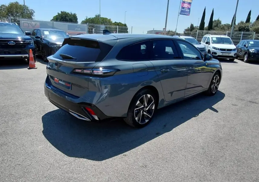 Peugeot 308 SW Hybrid gris vue 3/4 arrière droit, avec jantes alliage 17 pouces et feux arrière LED distinctifs.