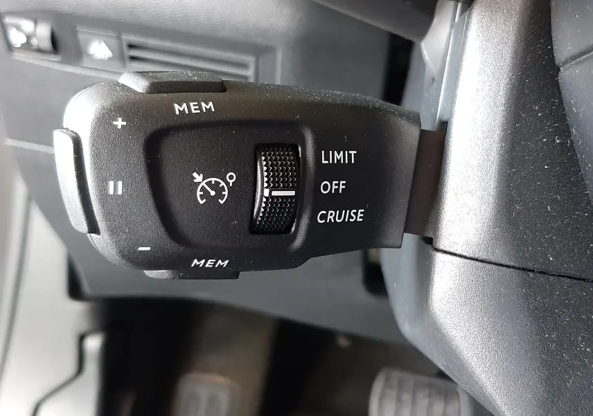 Gros plan sur la commande de régulateur de vitesse du DS3 Crossback 2020, côté gauche du volant, intérieur noir.