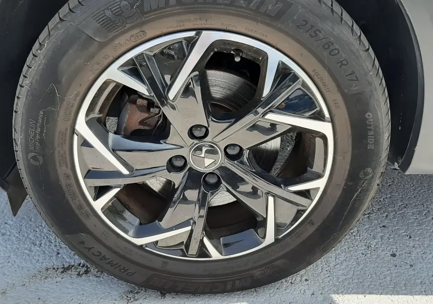Gros plan sur la roue avant droite du DS3 Crossback gris platinium, avec jante alliage bicolore et pneu Michelin.
