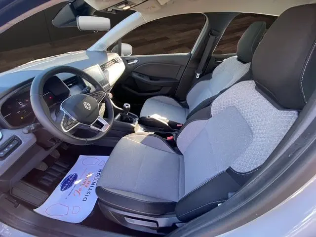 Intérieur avant de la Renault Clio V gris Rafale, sièges textile gris à motif 3D et volant textile grainé, vue côté conducteur.