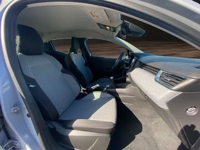 Intérieur avant droit de la Renault Clio V gris Rafale, sièges textile gris à motif 3D et tableau de bord moderne.