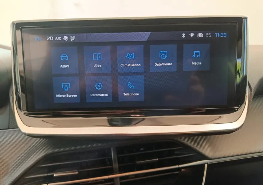 Écran tactile central de 10 pouces affichant les menus du système multimédia dans l'habitacle d'une Peugeot 208 gris foncé.
