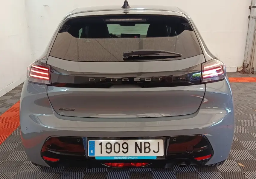 Vue arrière d'une Peugeot 208 gris foncé avec feux LED allumés et plaque d'immatriculation visible.