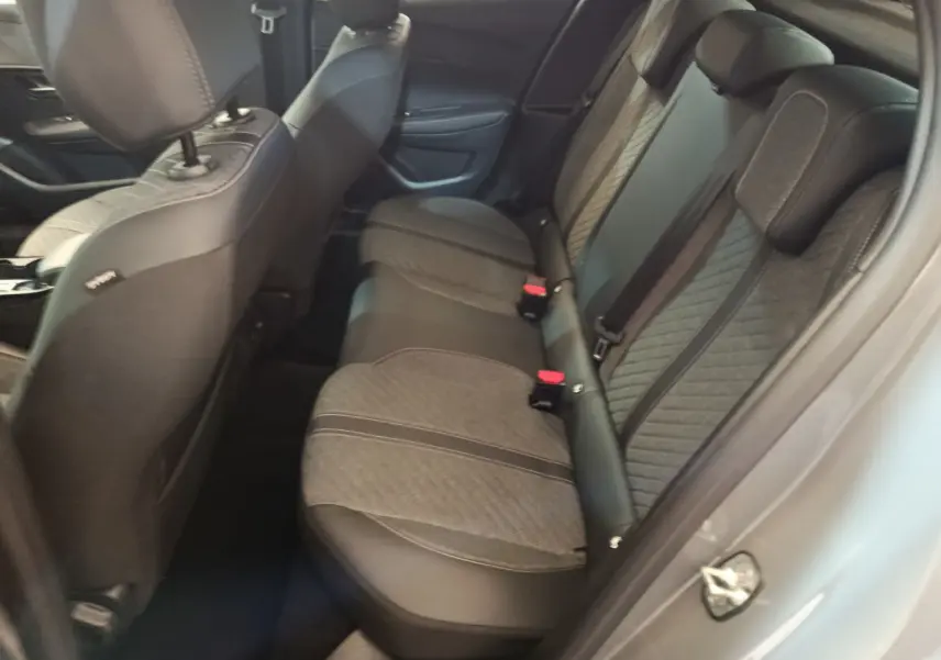 Vue côté gauche de l'intérieur arrière de la Peugeot 208 gris foncé, avec sièges tissu et cuir bicolore.