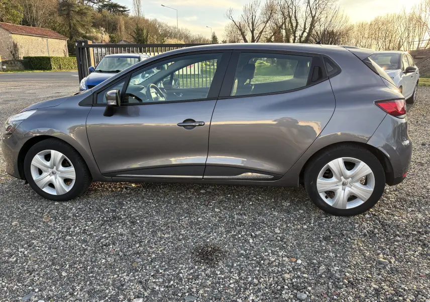 Profil côté gauche d'une Renault Clio IV gris métallisé de 2013, avec jantes et rétroviseur noir brillant.