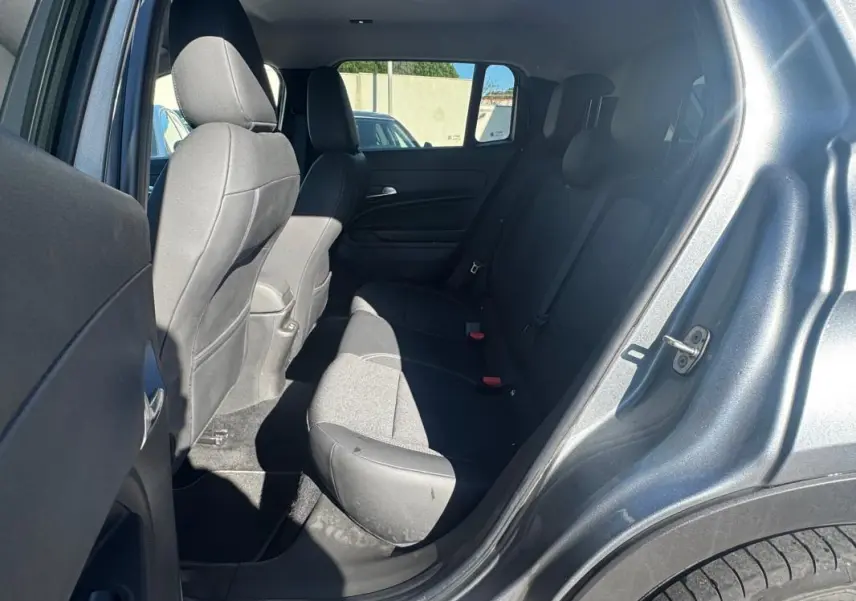 Vue intérieure côté arrière droit du Jeep Avenger gris 2025, montrant les sièges arrière et la portière ouverte.