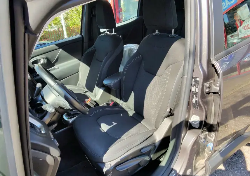 Vue intérieure côté conducteur du Jeep Renegade Granite Crystal 2020, sièges noirs et volant visible.