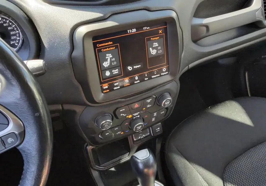 Vue intérieure centrée sur la console centrale et levier de vitesse d'une Jeep Renegade 2020, avec écran tactile allumé.