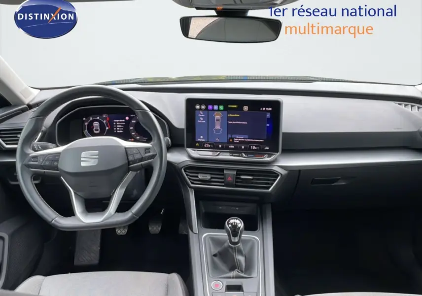 Vue intérieure frontale du tableau de bord et volant de la SEAT LEON ST bleu Fjord avec boîte manuelle et écran tactile central.