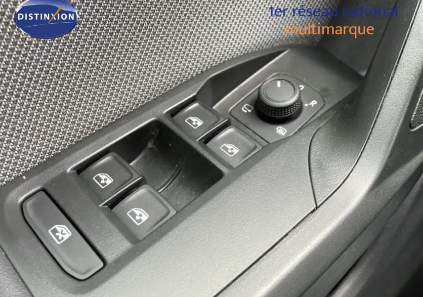 Gros plan sur les commandes de lève-vitres et réglage des rétroviseurs côté conducteur d’une SEAT LEON ST 2025.