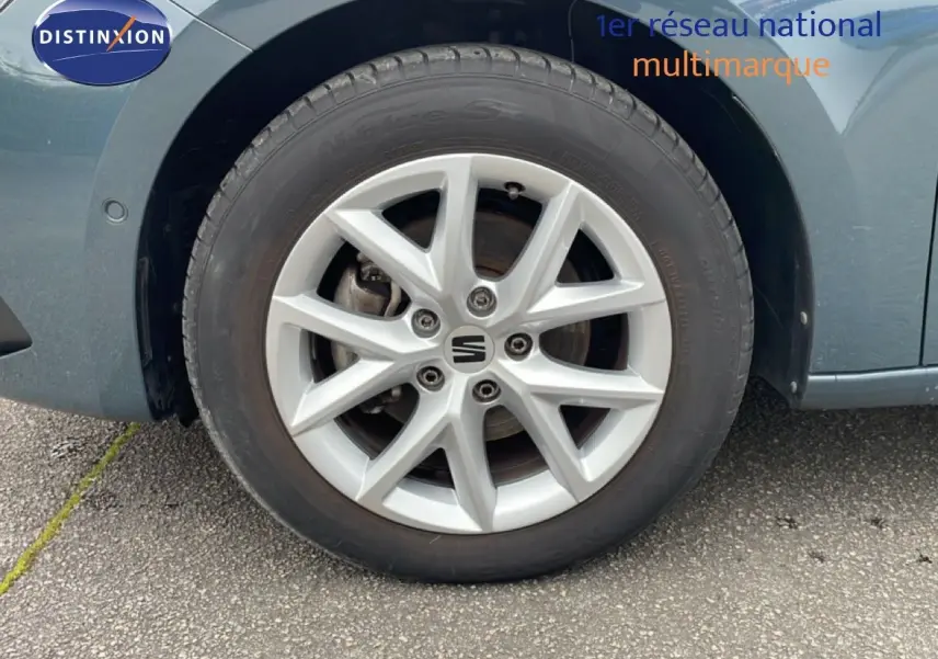 Gros plan sur la roue avant droite d'une SEAT LEON ST bleu Fjord, mettant en valeur la jante alliage argentée.