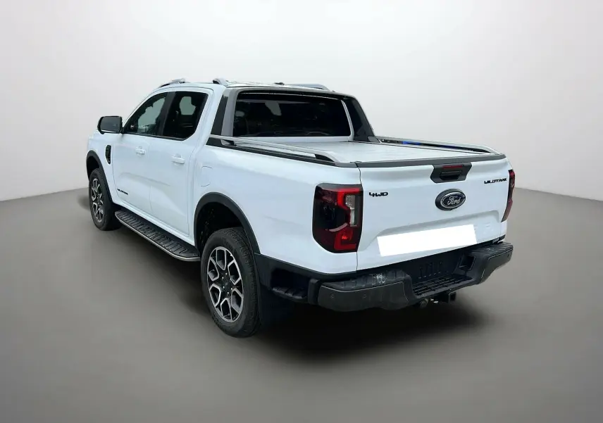 Ford Ranger 2.0 205 Wildtrak Plus blanc glacier, vue 3/4 arrière droit avec benne couverte et jantes alu 20 pouces.