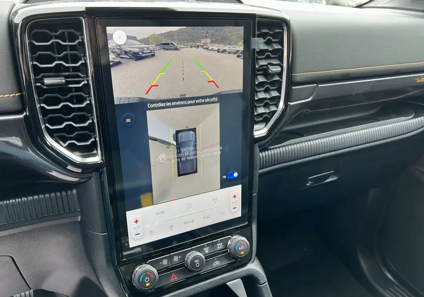 Vue rapprochée de l’écran tactile central du Ford Ranger Wildtrak blanc glacier, affichant la caméra 360° et les commandes climatisation.