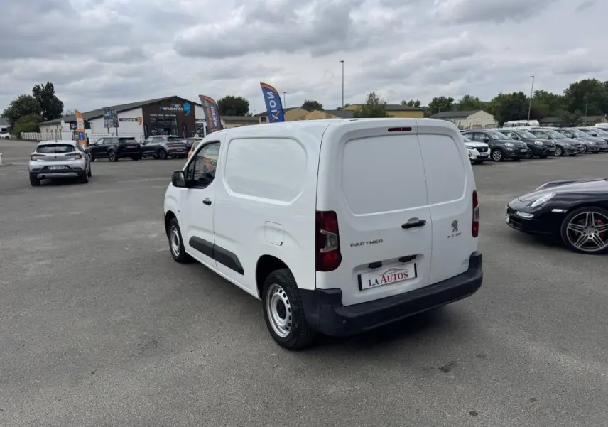 Vue 3/4 arrière droite d’un utilitaire Peugeot Partner blanc 2020 avec portes arrière pleines et pare-chocs noir.