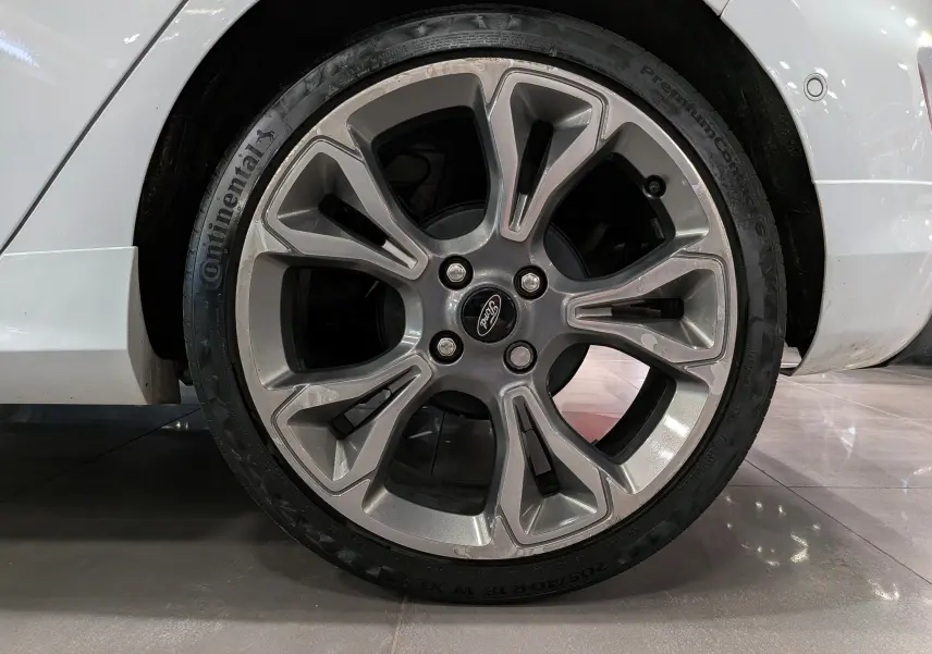 Gros plan sur la roue avant droite d'une Ford Fiesta blanche de 2020, avec jante alliage et pneu Continental.