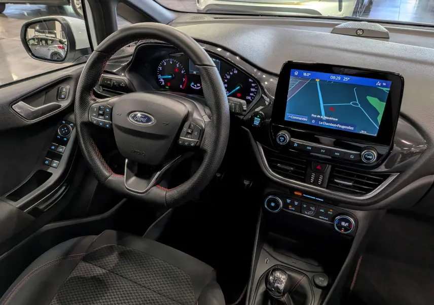 Vue intérieure de la Ford Fiesta 1.0 EcoBoost 2020, montrant le volant, tableau de bord et écran tactile de navigation.