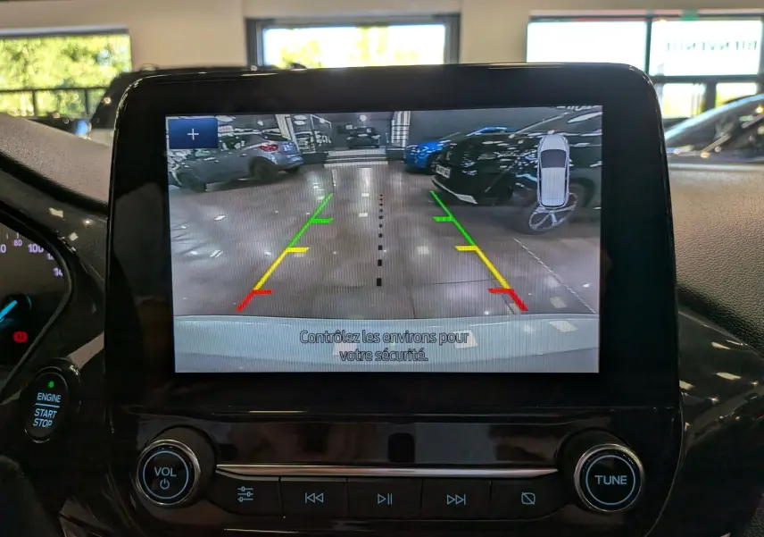 Écran central de la Ford Fiesta blanche 2020 montrant la caméra de recul avec lignes de guidage colorées en intérieur.