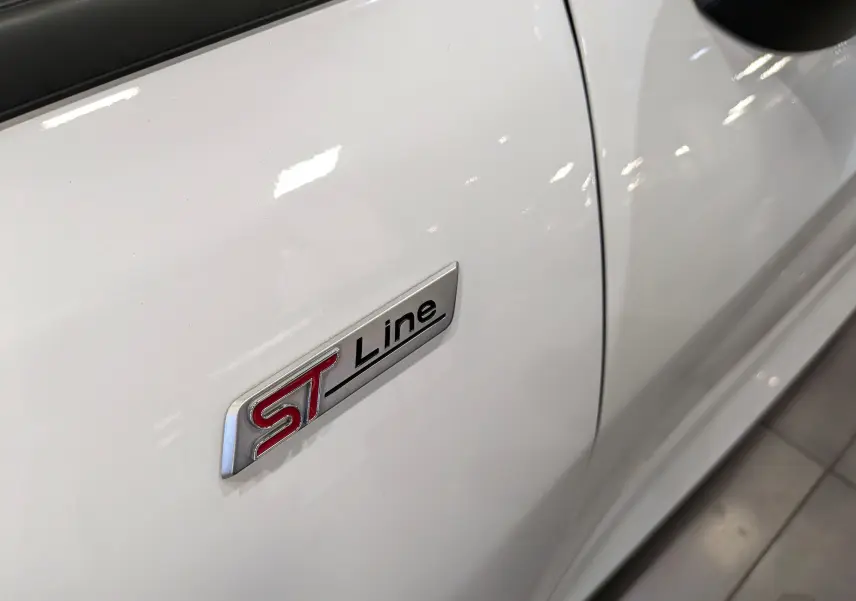 Gros plan sur l'écusson ST Line rouge et noir sur la porte blanche d'une Ford Fiesta 2020 côté droit.