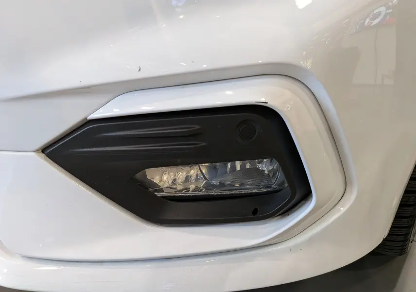 Gros plan sur le feu antibrouillard avant droit noir encadré de blanc sur une Ford Fiesta 2020 blanche.
