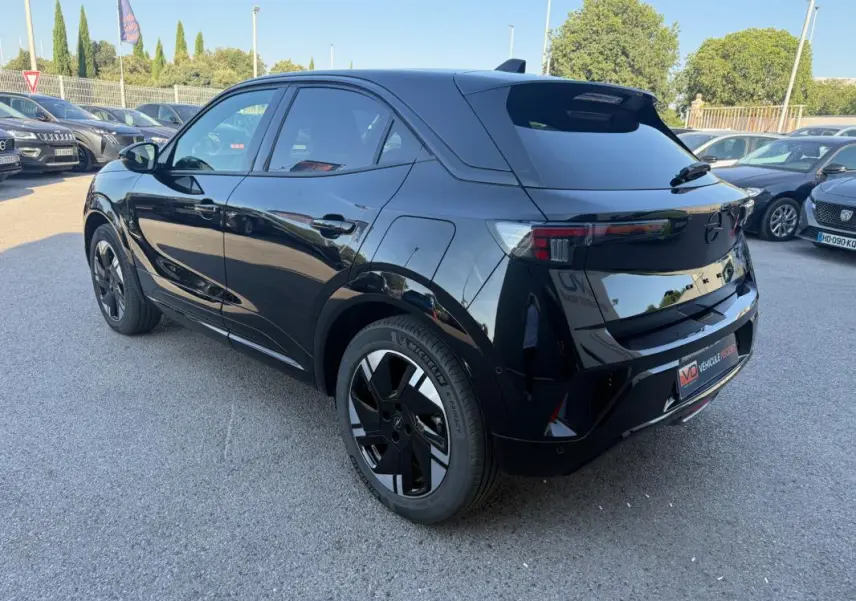 Opel Mokka électrique noir vue 3/4 arrière droit, jantes alliage 17 pouces et vitres surteintées visibles.