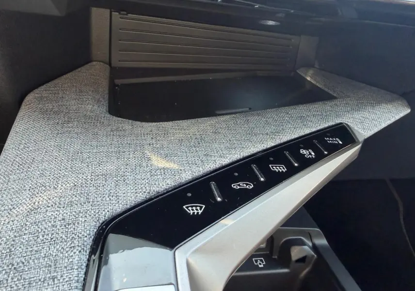 Détail de la console centrale du Peugeot 3008 Hybrid gris 2025, avec commandes tactiles et finition tissu grise.