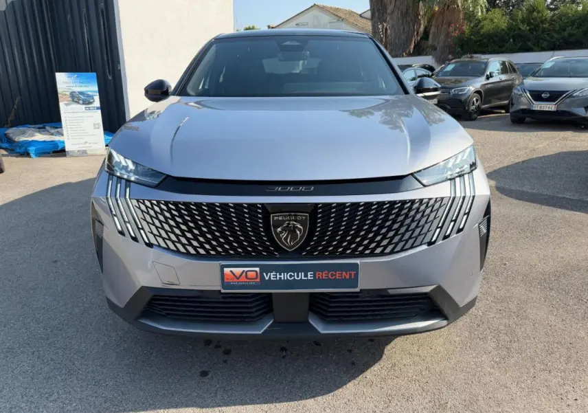 Vue avant frontale du Peugeot 3008 Hybrid gris 2025 avec calandre distinctive et phares LED fins.