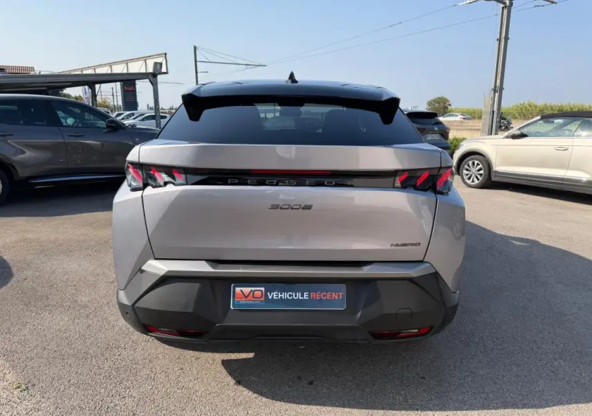 Vue arrière d’un Peugeot 3008 Hybrid gris 2025 avec feux arrière à griffes et toit noir contrasté.