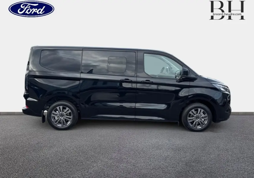 Vue latérale droite d'un Ford Transit Custom Fourgon noir Agate Métallisée avec jantes alu gris carbone et porte latérale coulissante double.