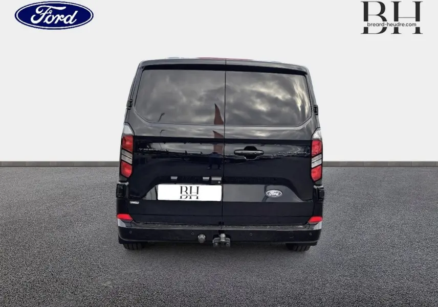 Vue arrière d'un Ford Transit Custom Fourgon noir Agate Métallisée avec crochet d'attelage et vitres arrière surteintées.