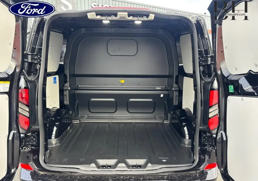 Vue arrière du fourgon Ford Transit Custom noir Agate Métallisée avec portes ouvertes montrant l’espace de chargement vide.