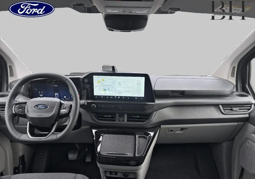 Vue intérieure avant du Ford Transit Custom Fourgon 2026, tableau de bord moderne avec écran tactile central et volant multifonction noir.