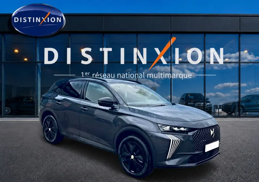 DS7 1.5 BlueHDi 130 gris titane en 3/4 avant droit, avec calandre distinctive et jantes noires brillantes.